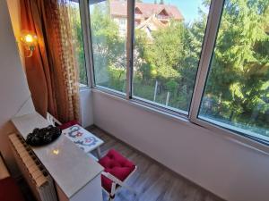 a room with a large window with a table and chairs at Cosy 2 rooms apartment with a view near the forest in Predeal