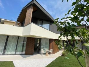 a house with a balcony with a table and chairs at Villa San Zeno Rooms in Bardolino