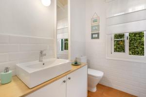 a white bathroom with a sink and a toilet at Sa Salada in Son Carrio