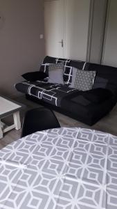 Sofá negro en una habitación con cama en La pause, en Saint-Agrève