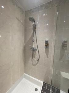 a shower with a shower head in a bathroom at Inspirations - Chambres d'hôtes in Saint-Loup-Géanges