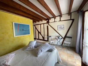 a bedroom with a bed in a room with wooden beams at Inspirations - Chambres d'hôtes in Saint-Loup-Géanges