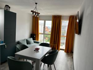 een woonkamer met een tafel en stoelen en een bank bij Boutique apartments 1 in Sînpetru