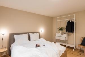 a bedroom with a large white bed and a dresser at SCHILCHERLANDLEBEN - Langegg in Greisdorf