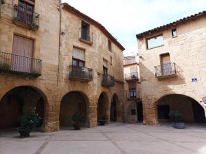 um antigo edifício de pedra com arcos num pátio em Els Ports d'Horta em Horta de San Joan