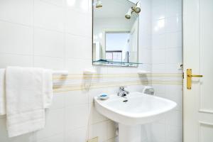 biała łazienka z umywalką i lustrem w obiekcie Espanhouse Simona estudio w mieście Torrevieja