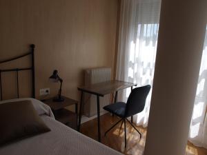 Schlafzimmer mit einem Schreibtisch, einem Stuhl und einem Bett in der Unterkunft Apartamento Sadar in Pamplona