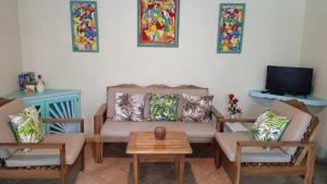 ラス・テレナスにあるLas Palmas Eco Residenceのリビングルーム(ソファ、椅子2脚、テレビ付)