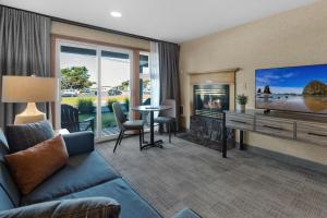un soggiorno con divano blu e TV di The Wayside Inn a Cannon Beach