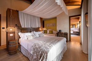 Conti Thun Wine Resort في بويجناجو: غرفة نوم بسرير كبير مع مظلة