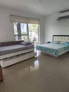 two beds in a room with a large window at Casa Campestre en Melgar in Melgar