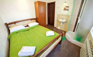 a bedroom with a green bed and a sink at Hotel Marinara in Odesa