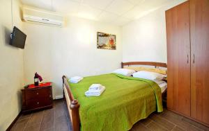 una camera con letto verde e armadio in legno di Hotel Marinara a Odessa