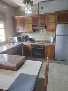 a kitchen with wooden cabinets and a white refrigerator at Casa Velay in Fisterra