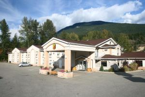 a large building with a car parked in a parking lot at Super 8 by Wyndham Revelstoke BC in Revelstoke