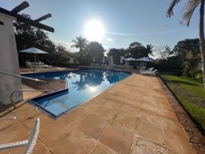 a swimming pool in a yard with a patio at Casa em geribá in Búzios