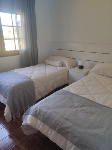 1 dormitorio con 2 camas y ventana en Casa Velay, en Finisterre