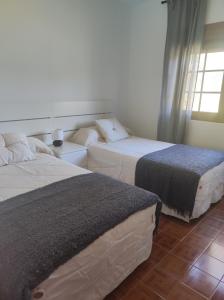 a bedroom with two beds and a window at Casa Velay in Fisterra