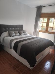ein großes Bett in einem Schlafzimmer mit Fenster in der Unterkunft Casa Velay in Fisterra