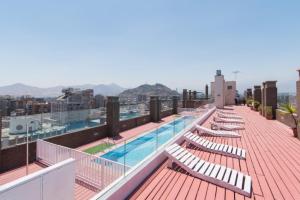 a row of lounge chairs on the roof of a building at VR Suite Santiago in Santiago