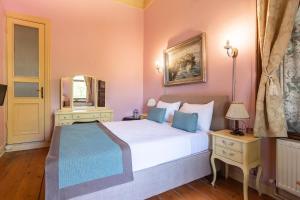 1 dormitorio con 1 cama blanca grande y espejo en Büyükada Anastasia Meziki History Mansion, en Büyükada