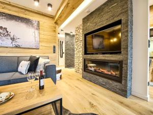ザコパネにあるVisitZakopane - Tatra Ski Apartmentのリビングルーム(暖炉、テレビ付)