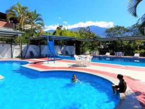 a man and a child in a swimming pool at Hotel Rupa Rupa in San Ramón