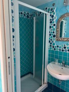 La salle de bains est pourvue d'une douche et d'un lavabo. dans l'établissement B&B Il Corallo, à Terracine