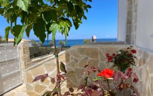 a view of the ocean from a stone wall with a flower at Villa Arkadia Seafront Villa Ai-Lagoudis Beach in Kyparissia