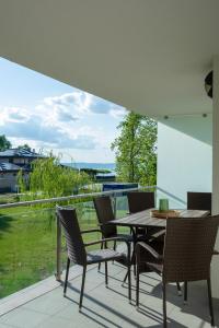 a patio with a table and chairs on a balcony at Római Panoráma apartman in Siófok