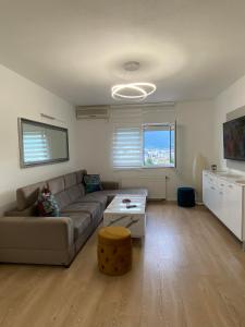ein Wohnzimmer mit einem Sofa und einem Tisch in der Unterkunft Mostar View House in Mostar