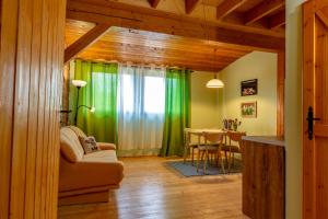 a living room with a table and green curtains at Kowalowe Skały SPA&MORE in Jelenia Góra
