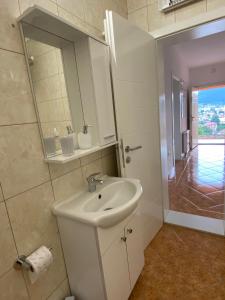 a white bathroom with a sink and a mirror at Mostar View House in Mostar