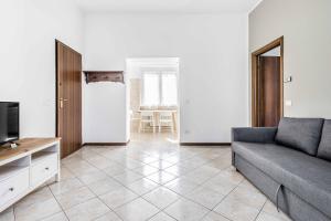 ein Wohnzimmer mit einem Sofa und einem TV in der Unterkunft Casa Vacanza via Sottocorno in Busto Arsizio