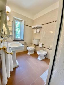 a bathroom with two toilets and a sink at Locanda Granducato in Chiusi