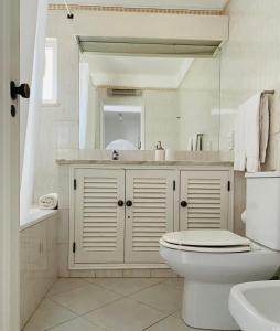 a bathroom with a toilet and a sink and a mirror at Casa da Balaia in Albufeira