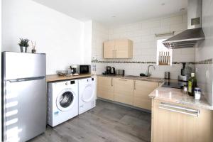 a kitchen with a white refrigerator and a washing machine at L'instant T 4* Balnéo, Sauna et Parking Privé in Colmar