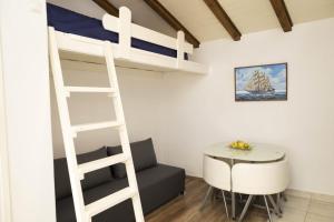 a room with a bunk bed and a table and a chair at M&T in Supetar