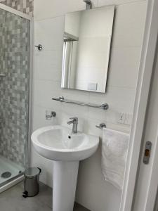 Un baño blanco con lavabo y espejo. en Villa Donnarumma, en Castellammare di Stabia 29 fotos más