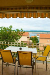a table and chairs on a balcony with a view at Apartment SeaShell in Jadranovo