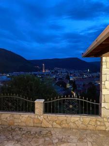 a view of a city at night from a stone fence at Mostar View House in Mostar