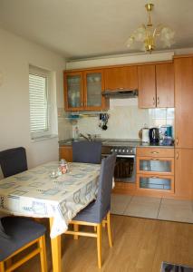 a kitchen with a table and chairs and a kitchen with a stove at Apartment SeaShell in Jadranovo