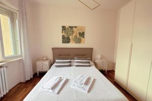 een slaapkamer met een bed met twee handdoeken erop bij La casa di Paola e Betti in Alba