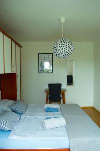 a bedroom with two beds and a chandelier at Apartment SeaShell in Jadranovo