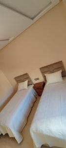 twee bedden in een kamer met witte muren bij Nador New in Nador