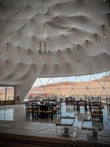 a large white tent with tables and chairs in it at Tower Rum Camb in Wadi Rum