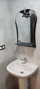 een badkamer met een wastafel en een spiegel bij Nador New in Nador