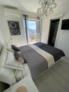 a bedroom with a large bed with a large window at Villa Ansay with heated Swim Spa pool and sea view in Zaton