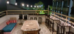 a balcony with a table and chairs and lights at White Hostel in Limassol