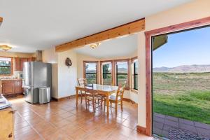 uma cozinha com uma mesa e um frigorífico em Peggy's View - Uplifting Cozy Mountain Views em Alpine